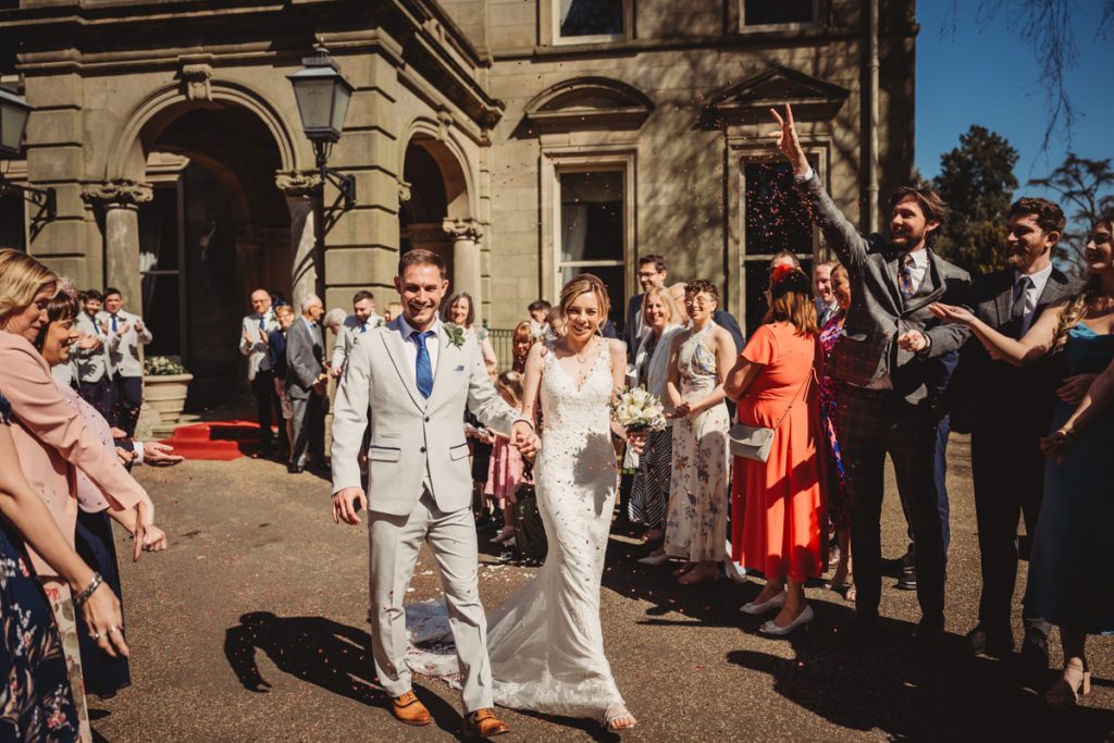 Bride and groom leaving ceremony, guests throw confetti at Kilworth House Hotel