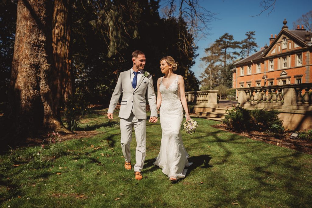 Bride and groom walking in garden at Kilworth House Hotel