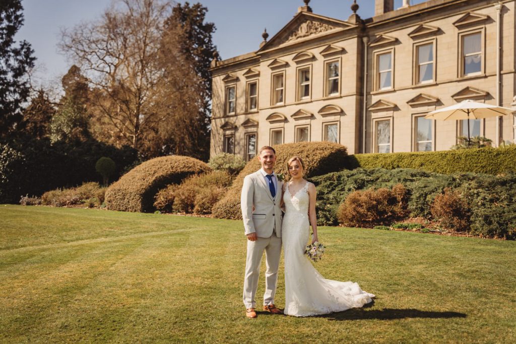 Wedding couple outside historic mansion on sunny day at Kilworth House Hotel