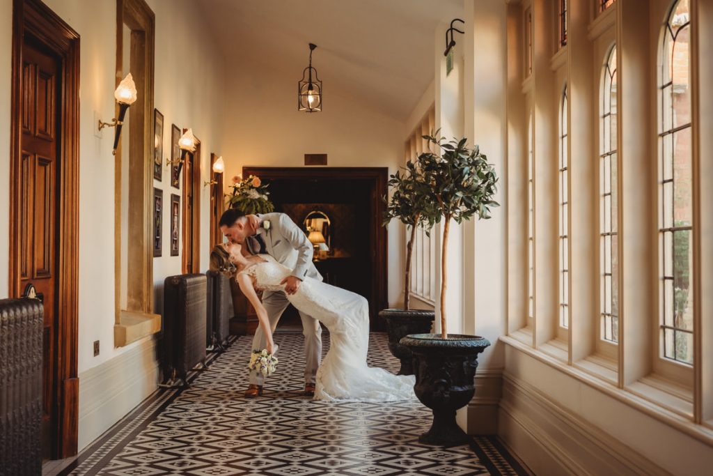 Bride and groom kissing in elegant hallway at Kilworth House Hotel