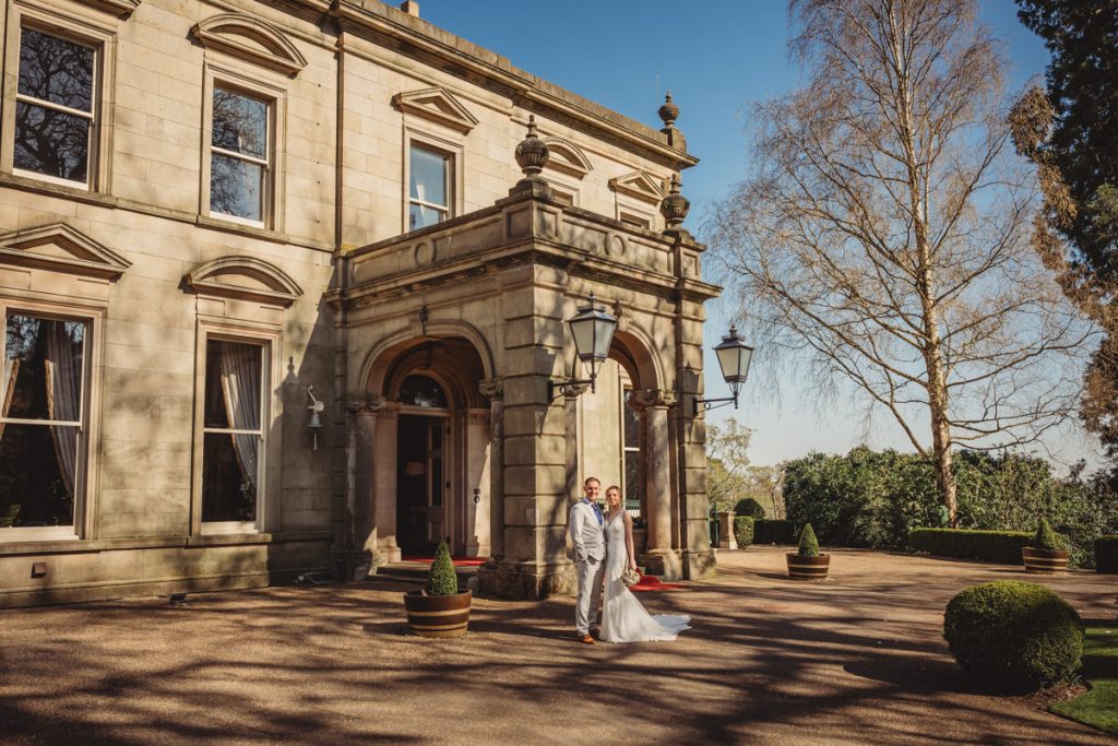 Couple outside historic stone building on sunny day Kilworth House Hotel