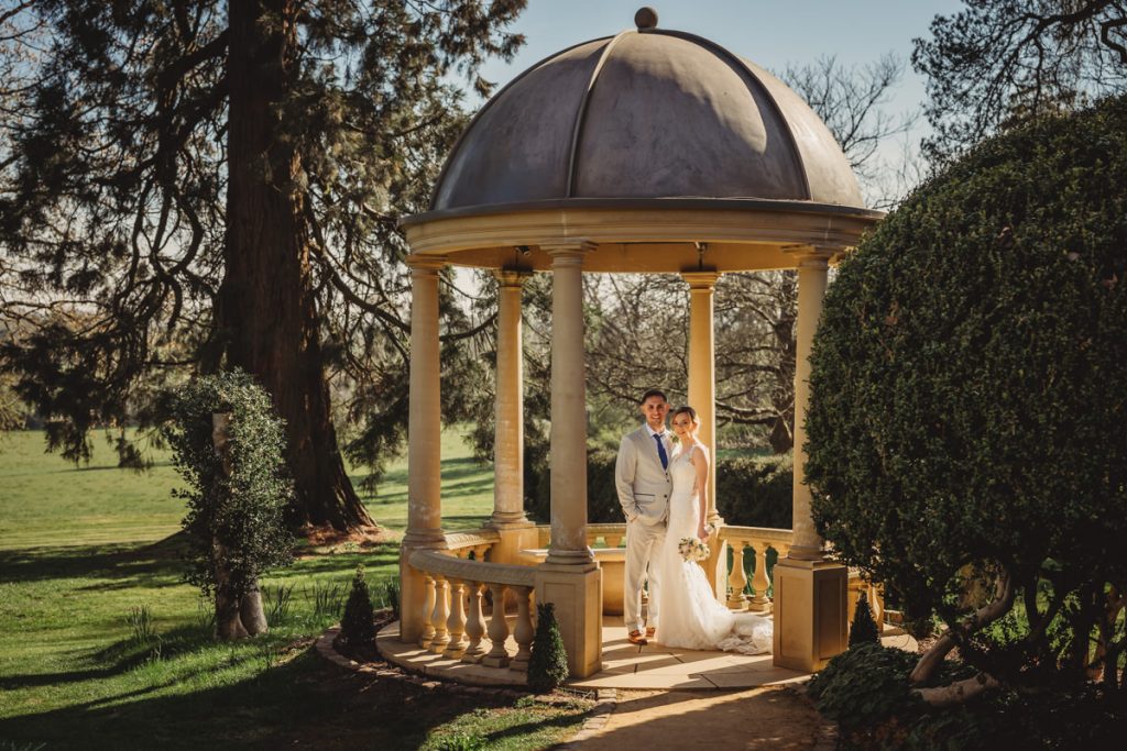 Bride and groom in gazebo surrounded by greenery at Kilworth House Hotel