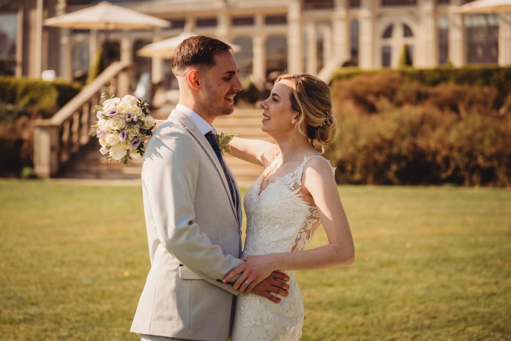 Bride and groom embrace outdoors, smiling at Kilworth House Hotel