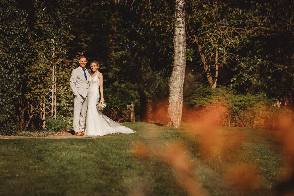 Bride and groom smiling in a garden setting at Kilworth House Hotel