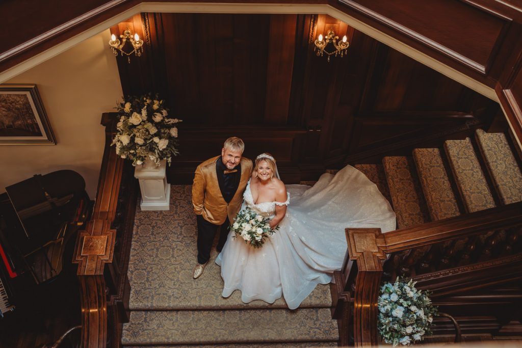 Bride and groom on elegant staircase wedding photo at Bourton Hall by Tom Stenlake Photography