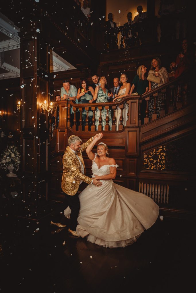 Wedding couple dancing in elegant venue with guests watching at Bourton Hall by Tom Stenlake Photography