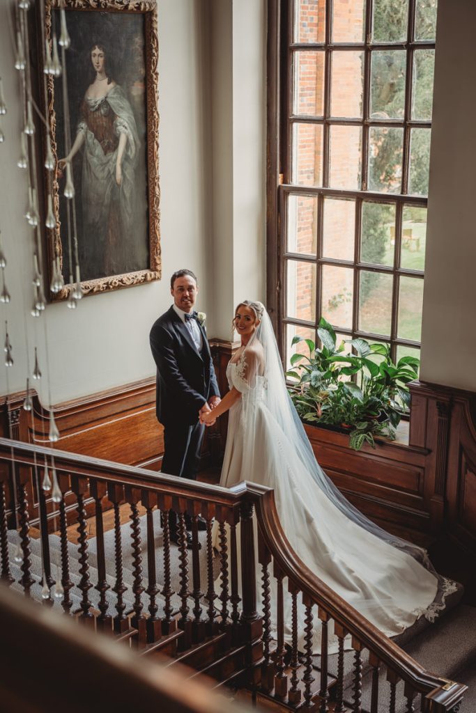 Bride and groom on elegant staircase indoors