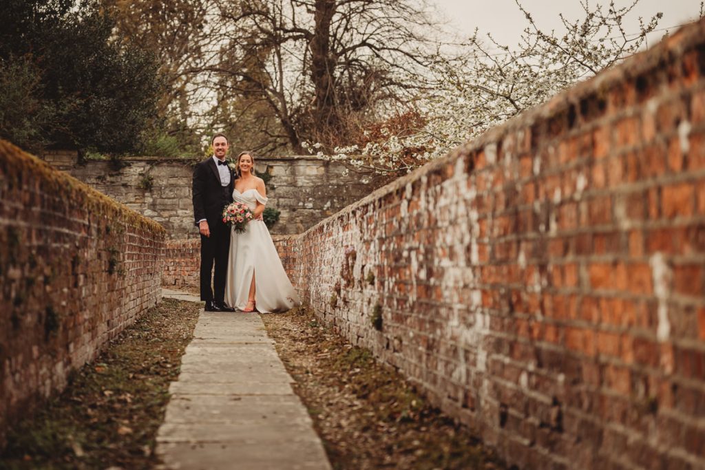 Bride and groom in garden walkway at Chicheley Hall
