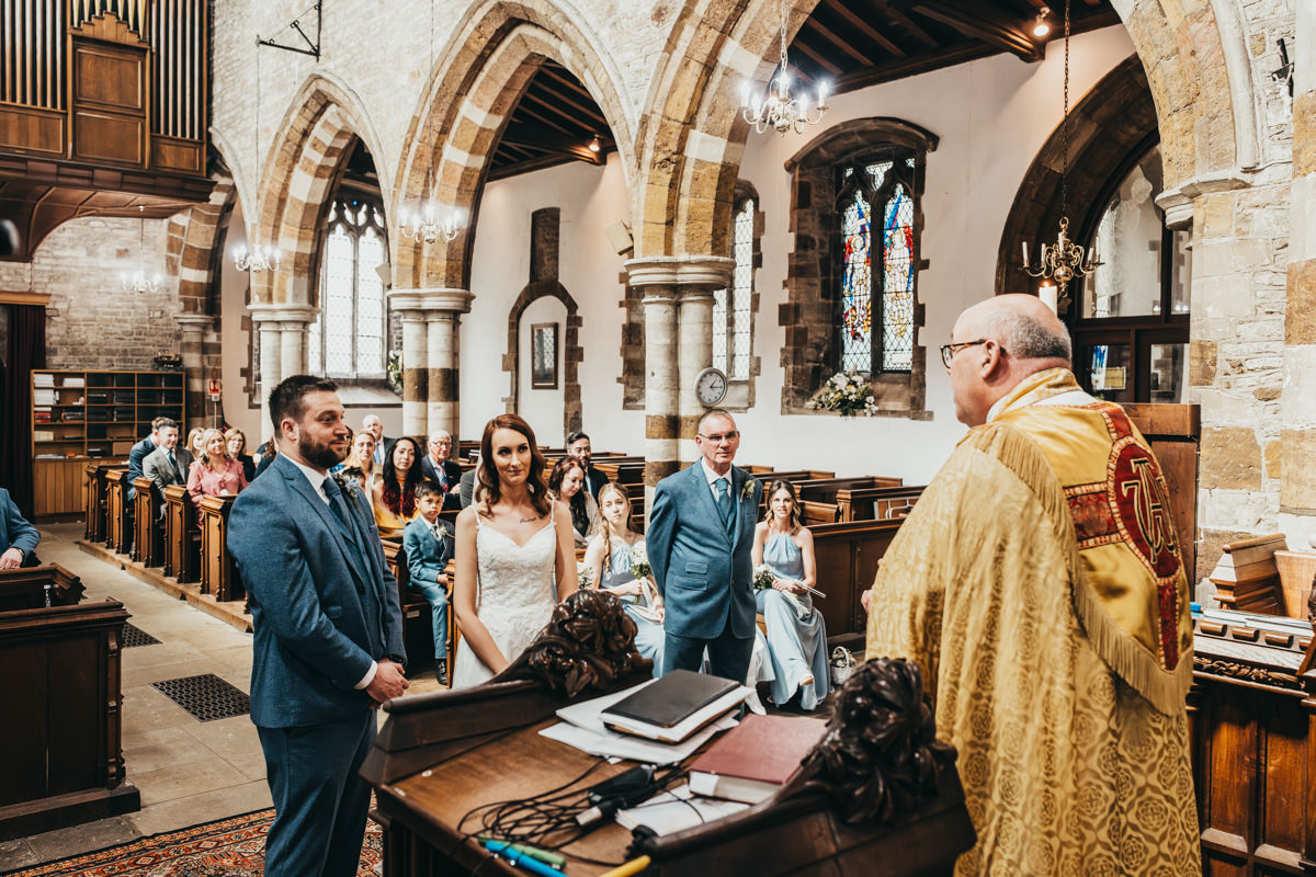 Wedding ceremony in historic church with guests attending.