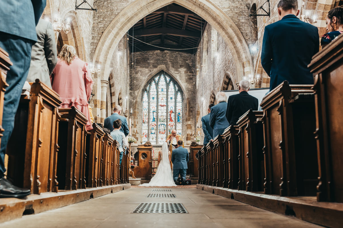 Bride and groom at church altar, wedding ceremony scene.