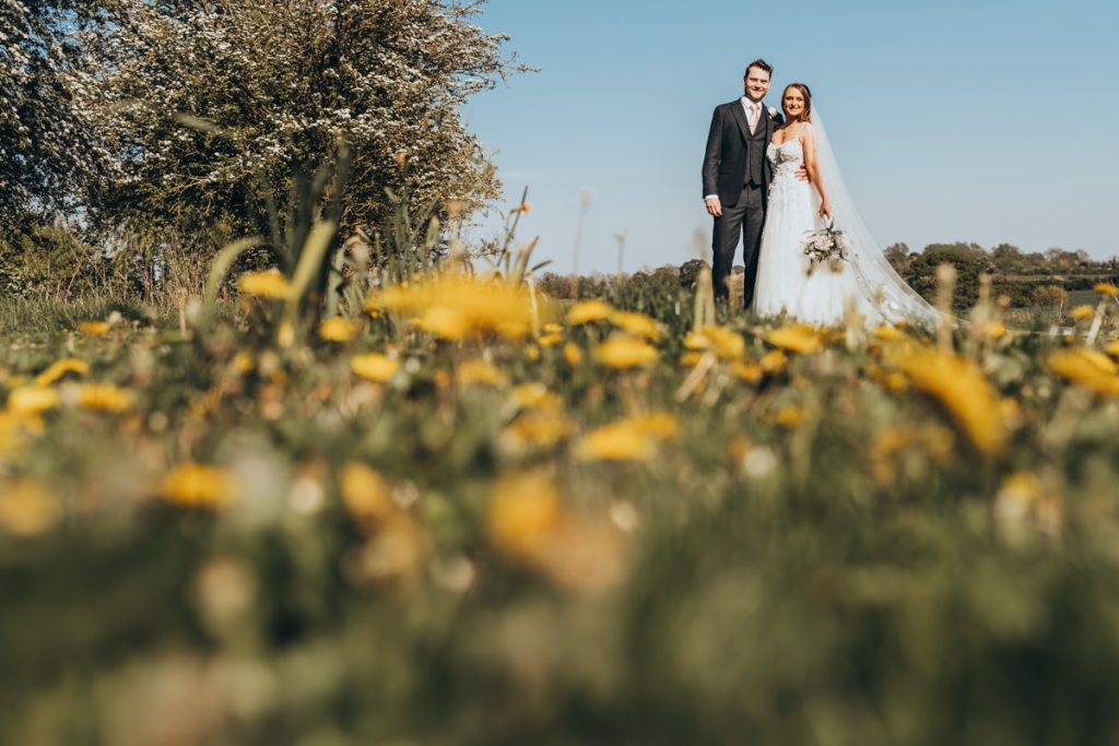 Wedding couple in flower-filled meadow at Huntsmill Farm