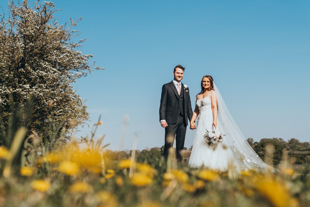 Bride and groom in sunny countryside wedding.