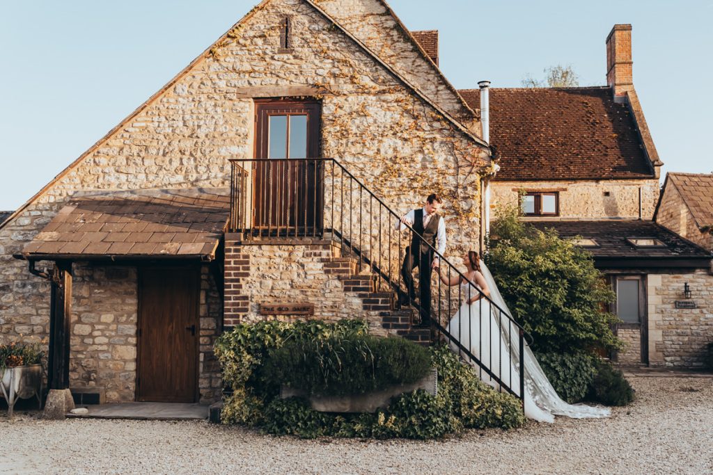 Bride and groom on rustic staircase at sunset at Huntsmill Farm